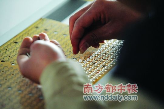工人忙著安裝用于燈具發(fā)光的LED燈珠，這類工作處于LED燈具生產(chǎn)的最下游。資料圖